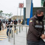 Policías persiguen a un presunto delincuente a pocas cuadras de la sede del canal de televisión TC, donde encapuchados armados ingresaron y sometieron a su personal durante una transmisión en vivo, en Guayaquil (Ecuador). EFE/Mauricio Torres