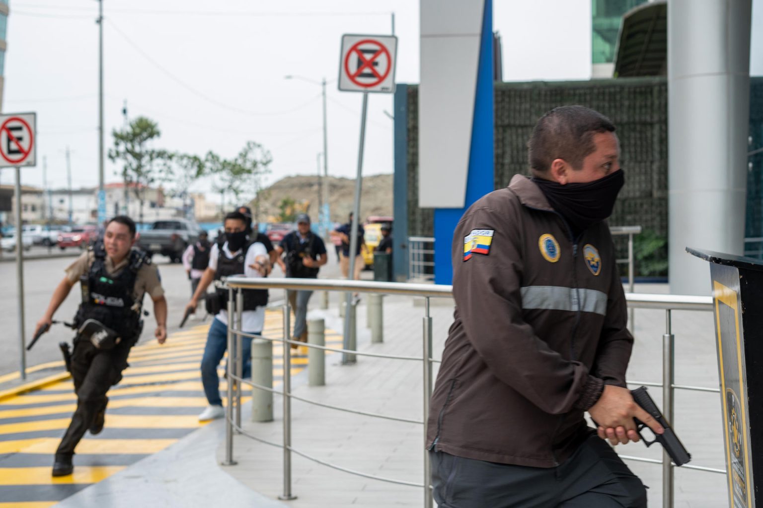 Policías persiguen a un presunto delincuente a pocas cuadras de la sede del canal de televisión TC, donde encapuchados armados ingresaron y sometieron a su personal durante una transmisión en vivo, en Guayaquil (Ecuador). EFE/Mauricio Torres