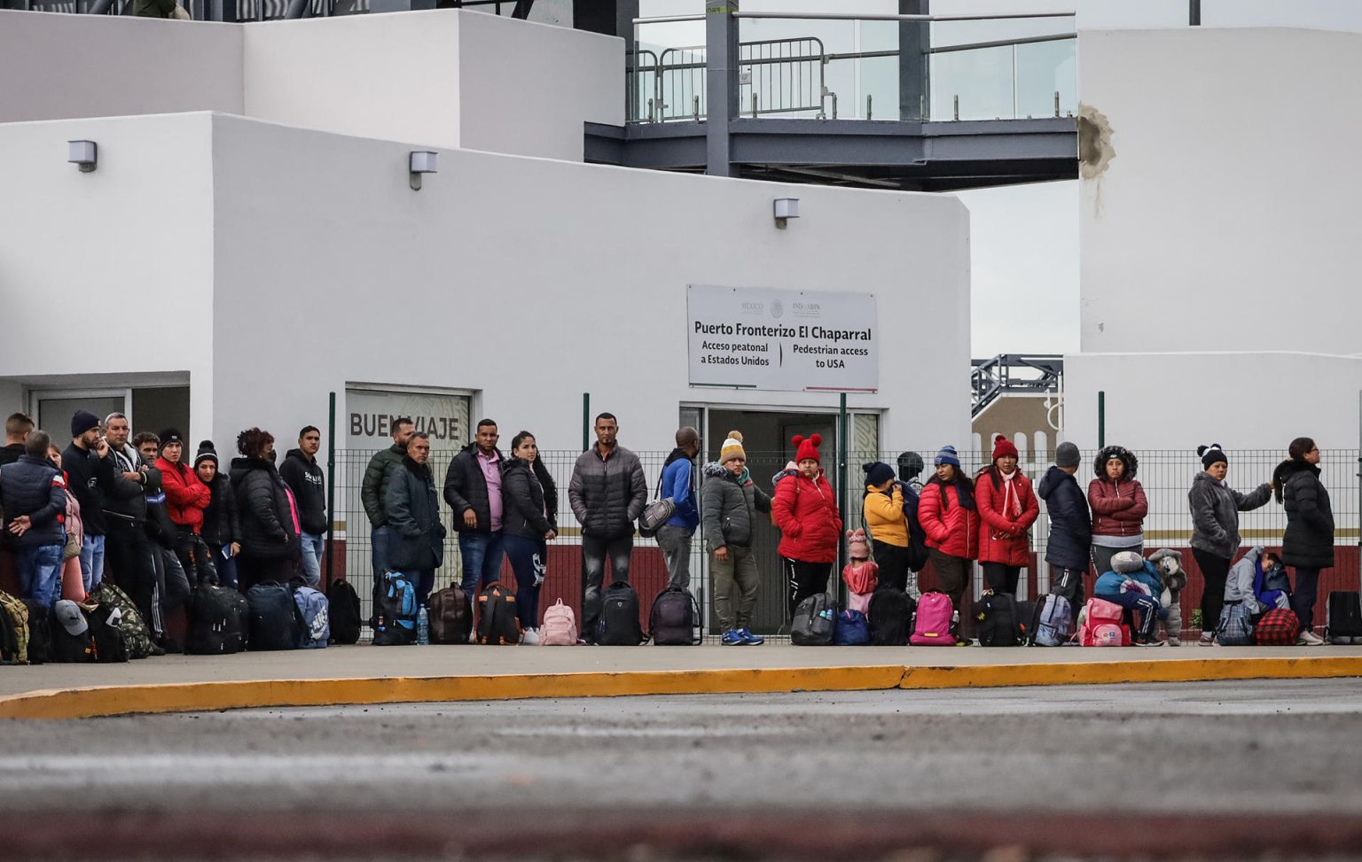 Migrantes hacen fila para solicitar un proceso de asilo en Estados Unidos en el puerto fronterizo del Chaparral en Baja California (México). Imagen de archivo. EFE/Joebeth Terríquez