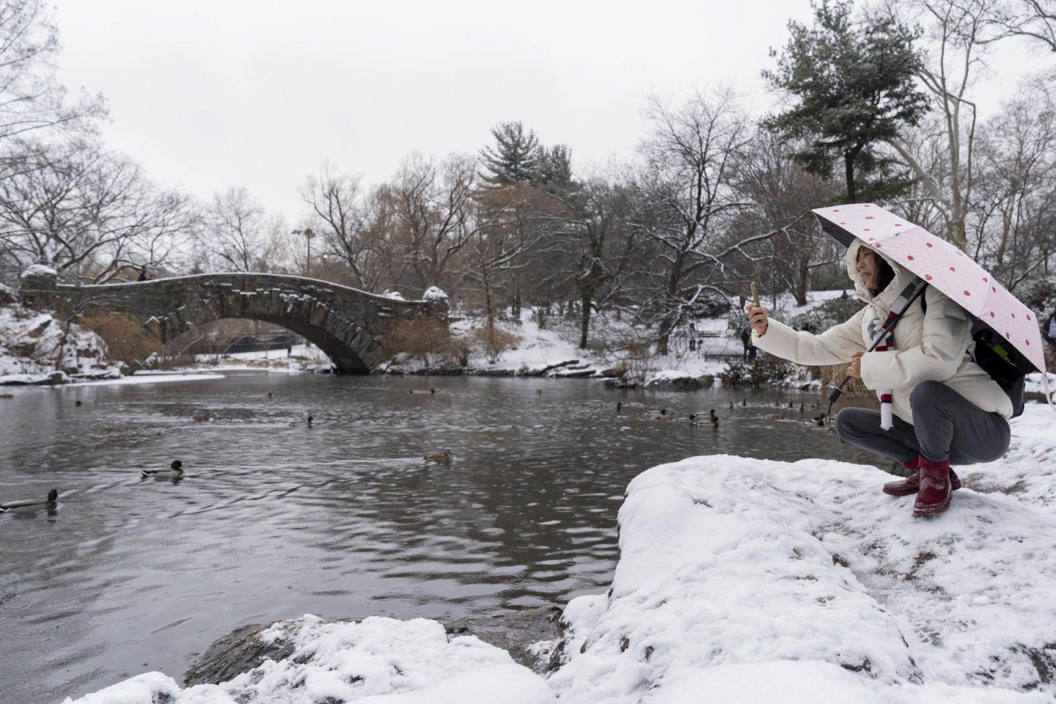 Una persona toma una fotografía al paisaje nevado en el lago en Central Park hoy, en Nueva York (EE.UU.). EFE/ Ángel Colmenares