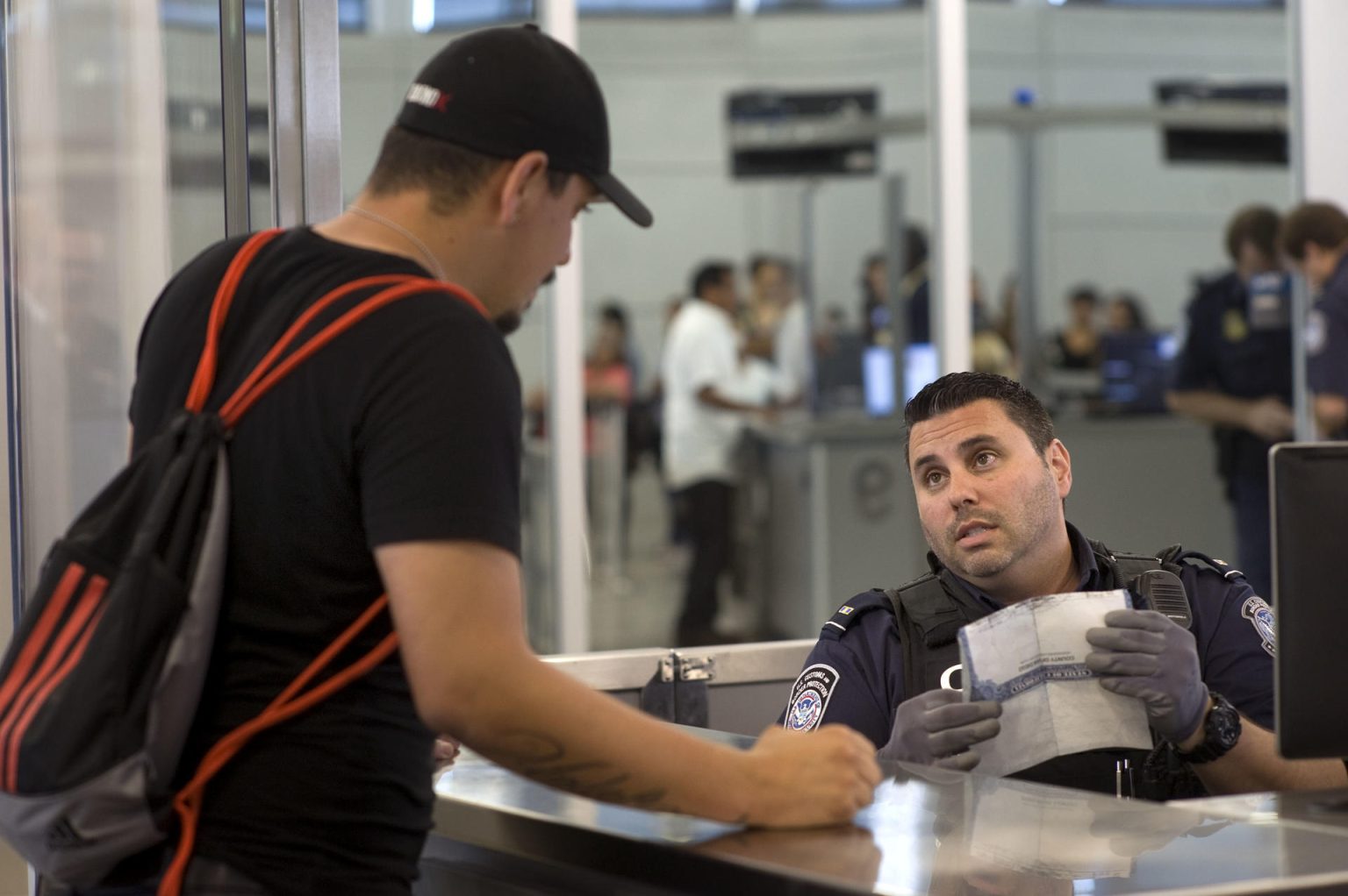 Fotografía de archivo de un agente de Aduanas y Protección de Fronteras (CBP) que pregunta a un mexicano que entra por el cruce peatonal denominado PedWest de San Ysidro. EFE/David Maung