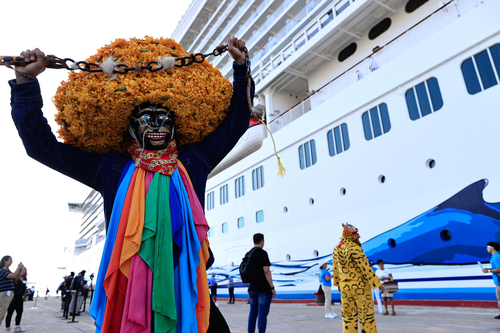 Un artista posa junto al barco de Norwegian Bliss tras su arribo hoy al puerto de Acapulco (México). EFE/ David Guzmán
