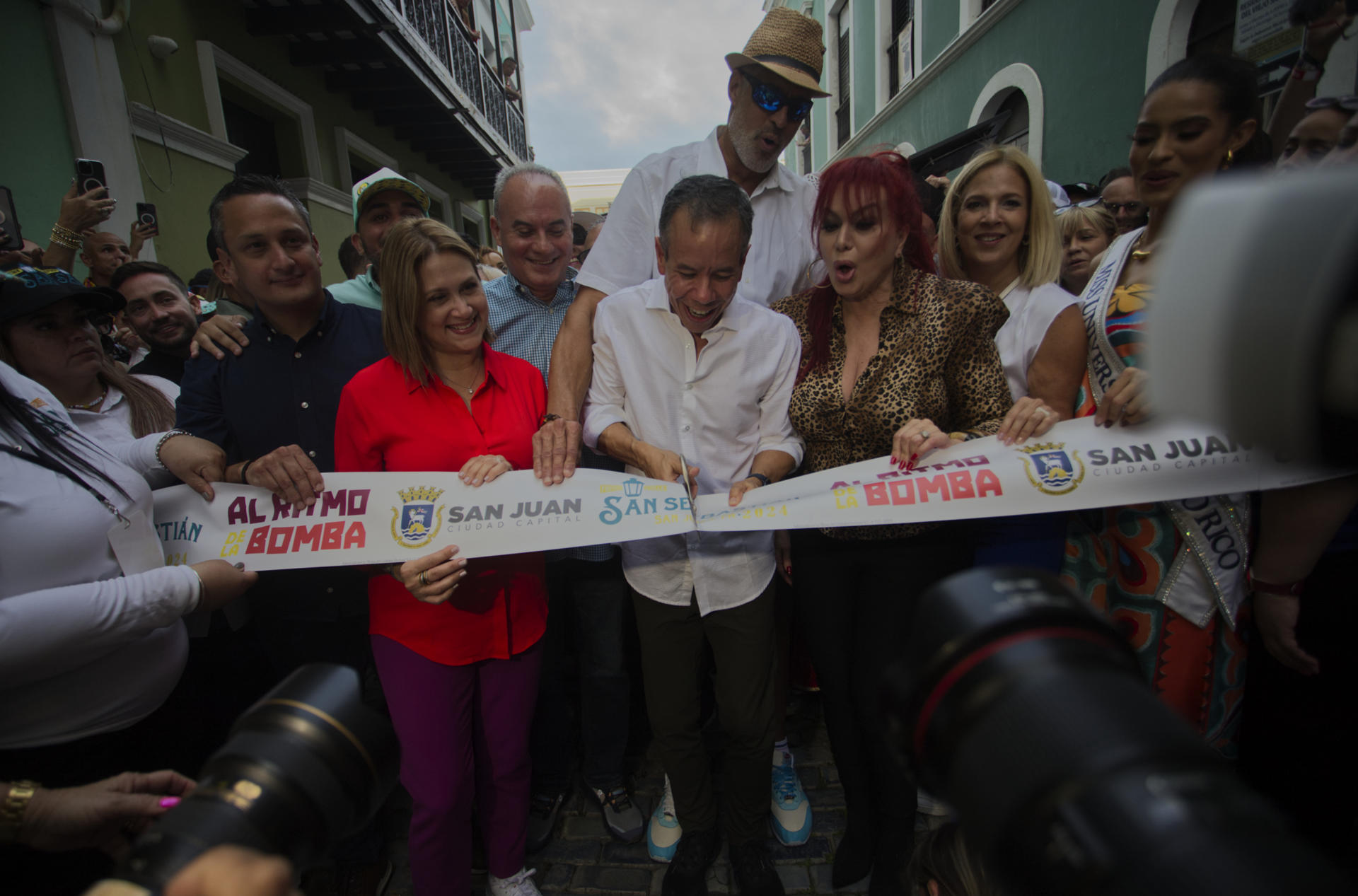 El alcalde de San Juan, Miguel Romero (c); la vedette Iris Chacon (c2) y el ex jugador de baloncesto Piculin Ortiz (detrás), cortan la cinta que da inicio a la edición numero 54 de las Fiestas de la Calle San Sebastián, hoy, en San Juan (Puerto Rico). EFE/ Thais Llorca
