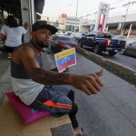 El migrante venezolano Gerardo Rafael Pérez pide ayuda frente a una estación de transporte público fuera de servicio en Tegucigalpa (Honduras). EFE/ Gustavo Amador