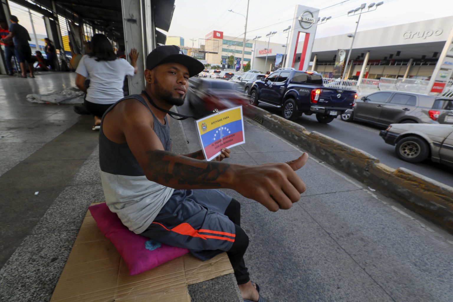 El migrante venezolano Gerardo Rafael Pérez pide ayuda frente a una estación de transporte público fuera de servicio en Tegucigalpa (Honduras). EFE/ Gustavo Amador