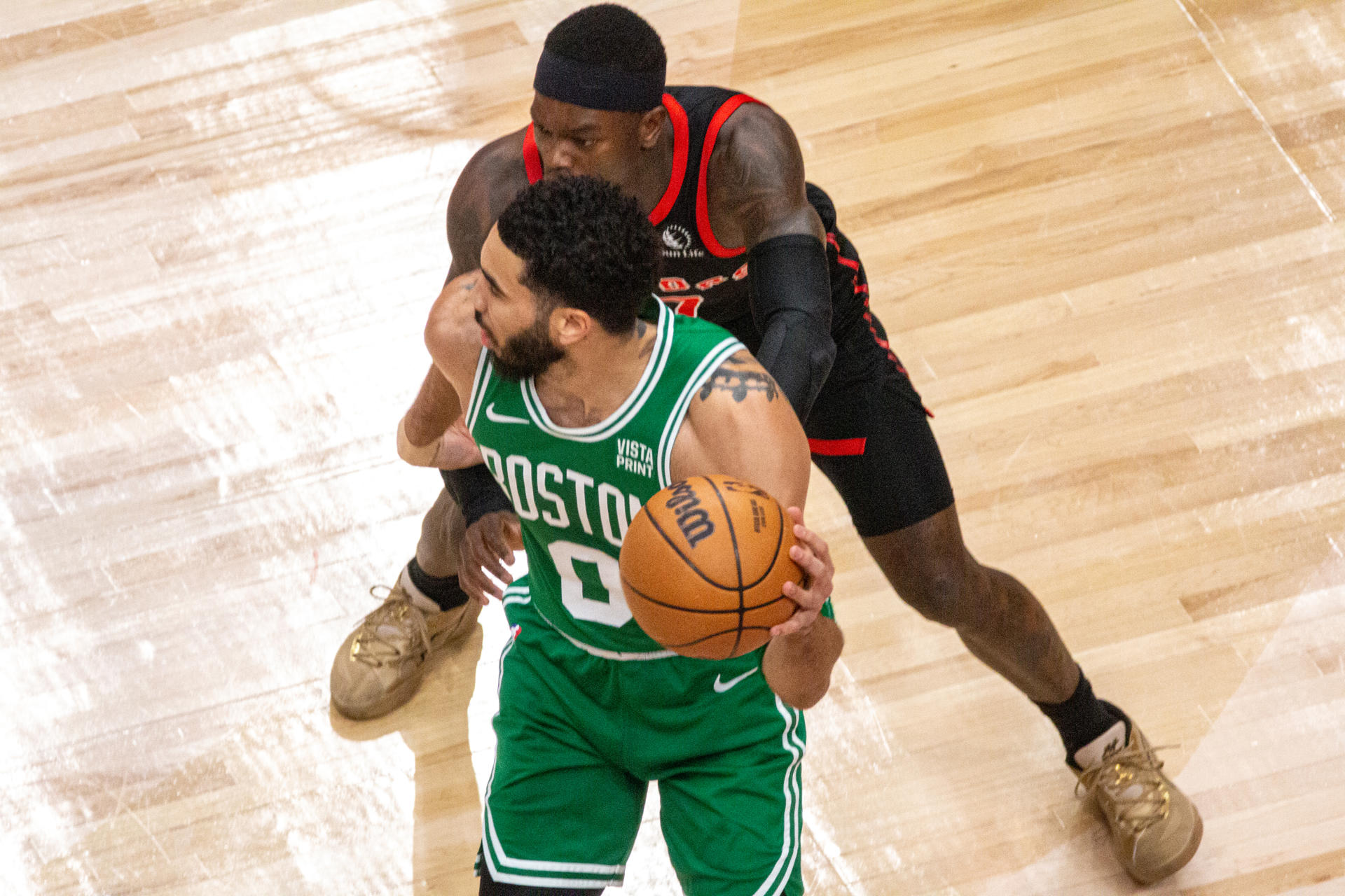 Jayson Tatum protege el balón ante la presión de Dennis Schroder durante un partido entre los Raptors y los Celtics, hoy en Toronto (Canadá). EFE/Julio César Rivas
