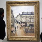 Personas observan el cuadro "Rue Saint-Honoré por la tarde. Efecto de lluvia" (1897), de Camille Pissarro, el 10 de enero de 2024 en el Museo Thyssen-Bornemisza en Madrid (España). EFE/ Sergio Pérez