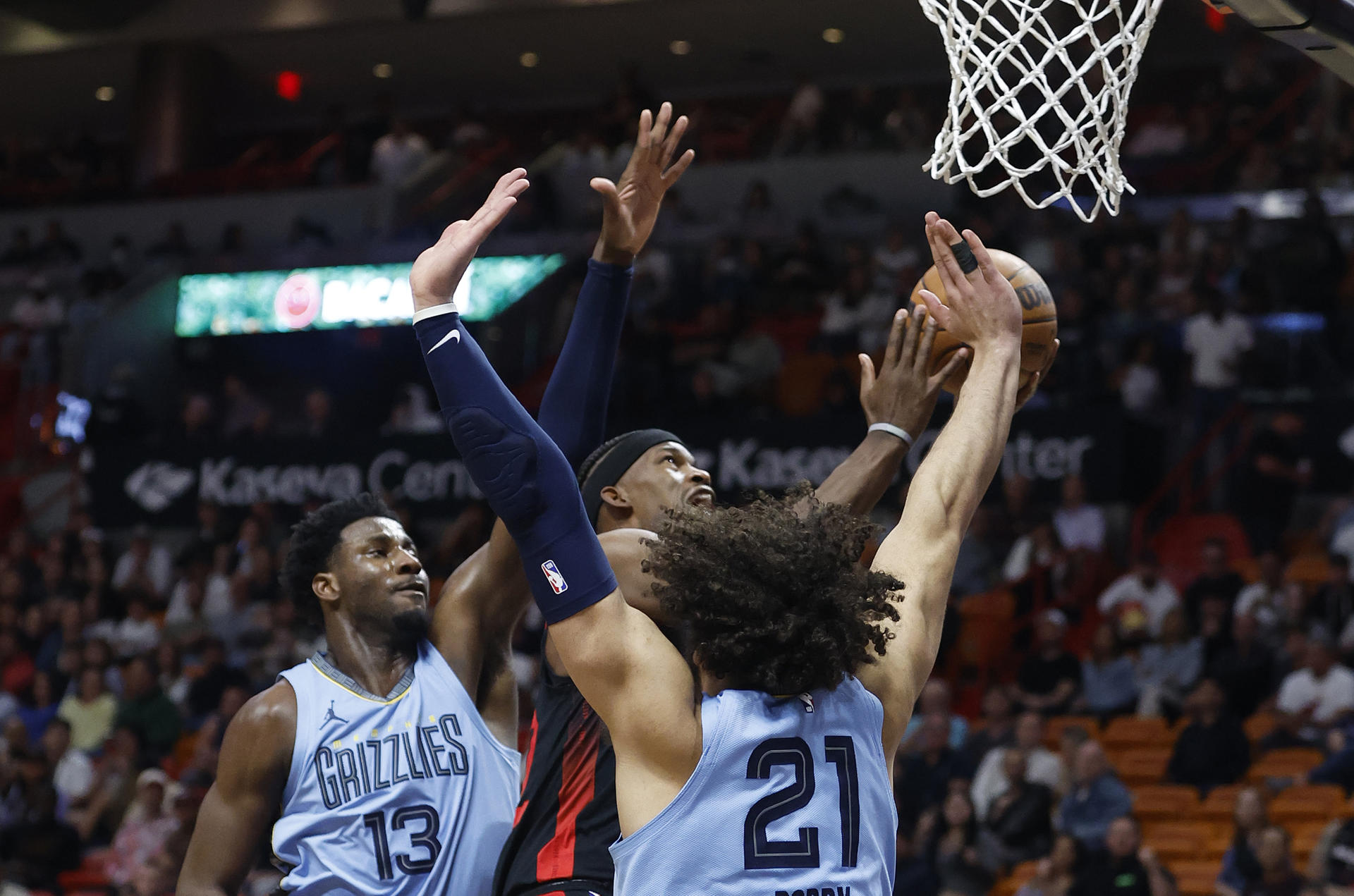 El delantero del Miami Heat Jimmy Butler (C) dispara entre el delantero de los Memphis Grizzlies, Jaren Jackson Jr. (izq.) y el delantero David Roddy (der.) durante la segunda mitad del partido de baloncesto de la NBA. EFE/ Rhona Wise
