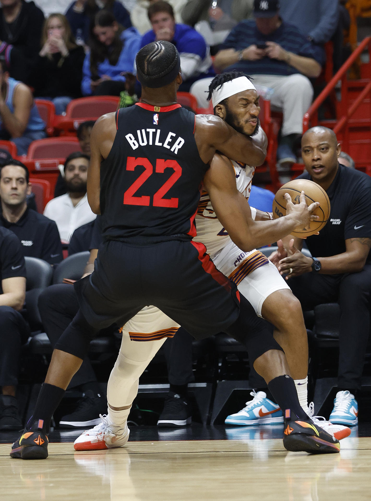 El delantero del Miami Heat, Jimmy Butler (izq.), defiende al guardia de los Phoenix Suns, Devin Booker (der.) hoy, durante la primera mitad del partido de baloncesto de la NBA entre los Miami Heat y los Phoenix Suns en el Kaseya Center de Miami, Florida (EE. UU). EFE/ Rhona Wise
