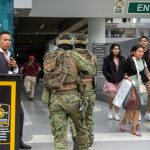 Soldados ecuatorianos persiguen hoy a un presunto delincuente mientras ciudadanos evacúan a pocas cuadras de la sede del canal de televisión TC, donde encapuchados armados ingresaron y sometieron a su personal durante una transmisión en vivo, en Guayaquil (Ecuador). EFE/Mauricio Torres