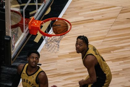 R.J. Barrett y Scottie Barnes de Raptors observan un balón este jueves, durante un partido de la NBA entre Toronto Raptors y los Brooklyn Nets, en Toronto (Canadá). EFE/Julio César Rivas