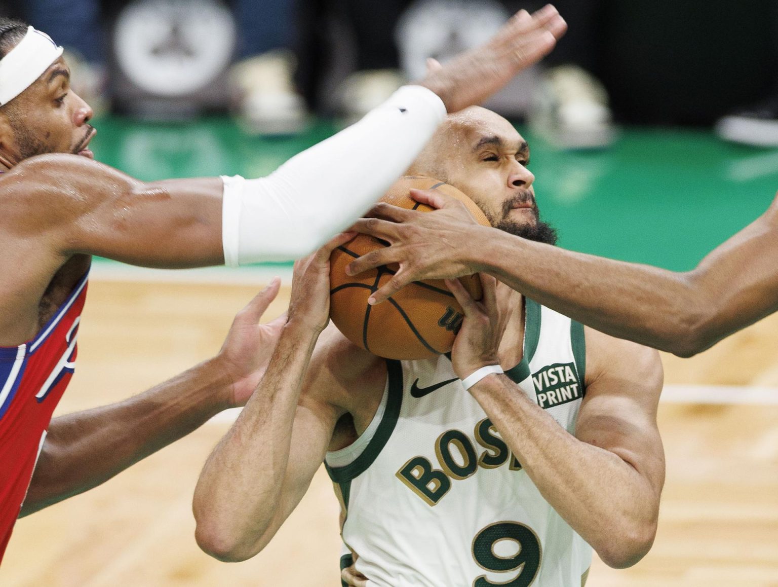 Derrick White (d), guardia de los Celtics de Boston, fue registrado este martes, 27 de febrero, al intentar superar la marca de Buddy Hield (i), de los 76ers de Filadelfia, durante un partido de la NBA, en Boston (Massachusetts, EE.UU.). EFE/CJ Gunther