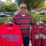 El vendedor José Godoy muestra unas camisetas de béisbol de Puerto Rico y México hoy, en Miami (Estados Unidos). EFE/Antoni Belchi