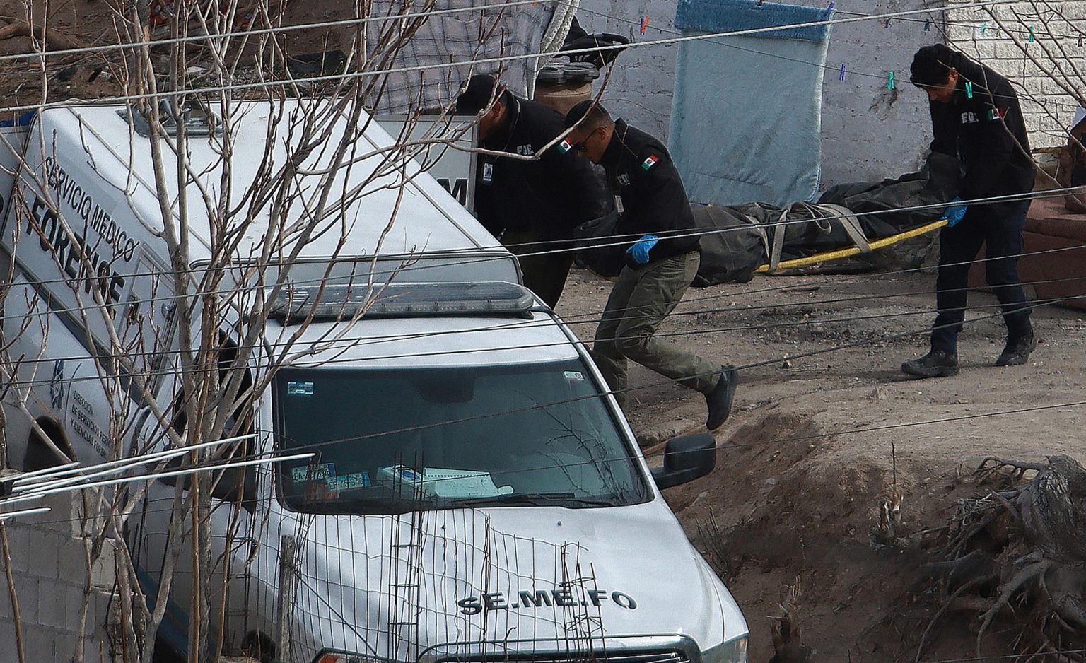 Peritos forenses trasladan un cuerpo localizado en una fosa clandestina el 16 de febrero de 2024, en Ciudad Juárez, estado de Chihuahua (México). EFE/Luis Torres