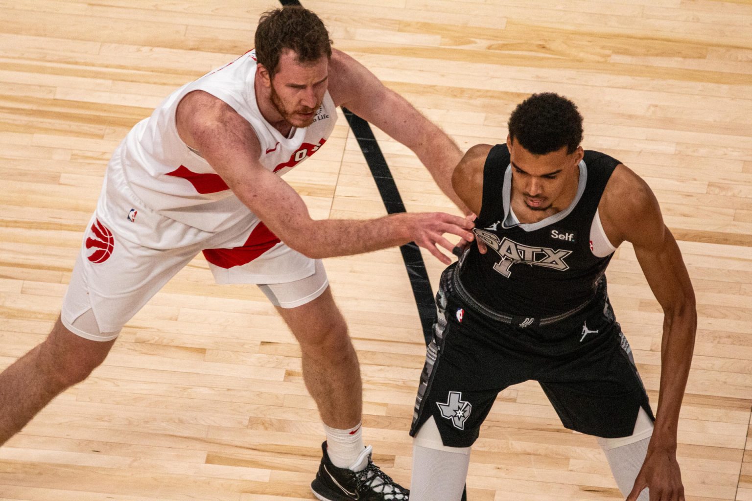 Victor Wembanyama (d) Toronto Raptors disputan un balón con Jakob Poeltl de San Antonio Spurs hoy, durante un partido de la NBA entre Toronto Raptors y los San Antonio Spurs, en el Scotiabank Arena, en Toronto (Canadá). EFE/ Julio César Rivas