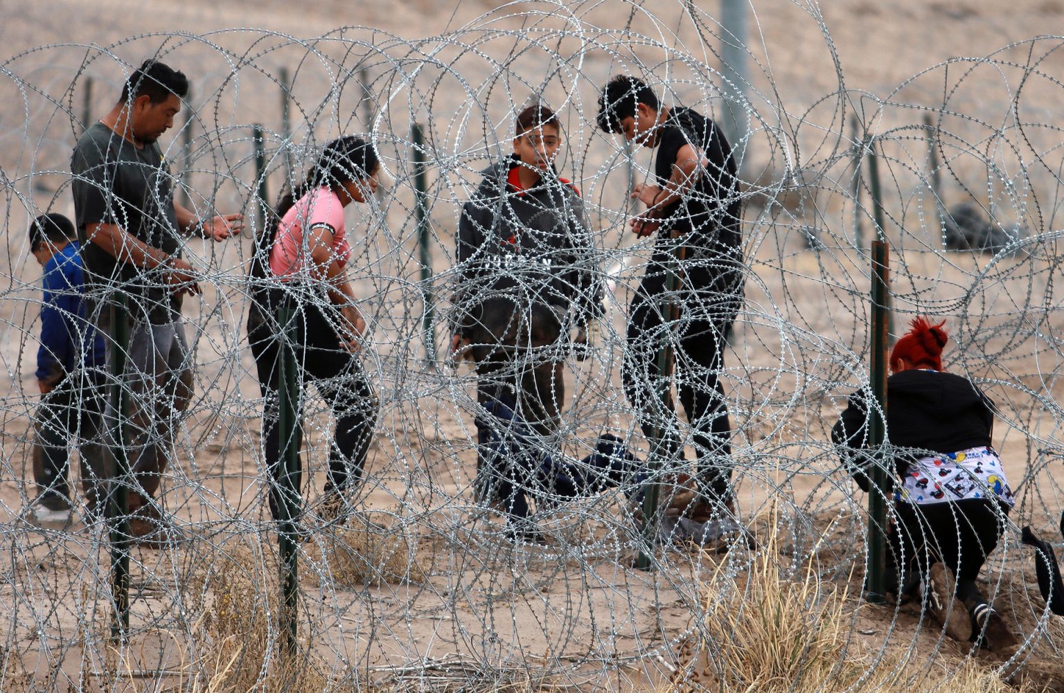 Migrantes intentan cruzar la cerca de alambres en la frontera que divide a México de los Estados Unidos, el 8 de febrero de 2024, en Ciudad Juárez (México). EFE/Luis Torres