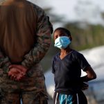 Un niño migrante habla con un agente del Servicio Nacional de Fronteras de Panamá en una Estación de Recepción de Migrantes (ERM) en Lajas Blancas, provincia del Darién (Panamá). Fotografía de archivo. EFE/ Bienvenido Velasco