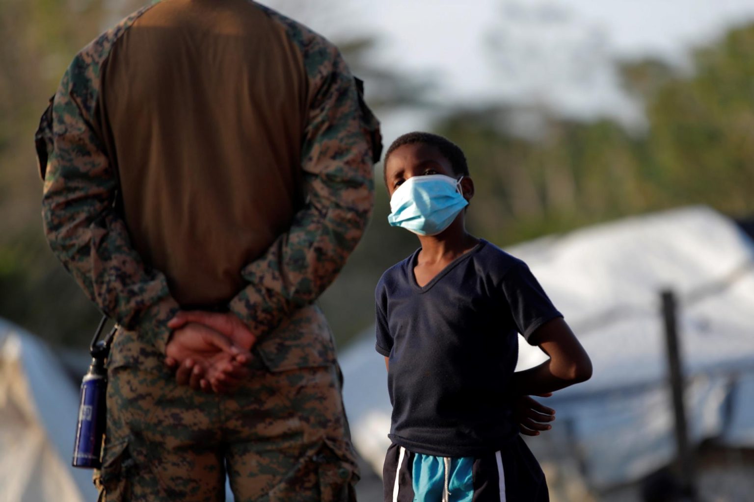 Un niño migrante habla con un agente del Servicio Nacional de Fronteras de Panamá en una Estación de Recepción de Migrantes (ERM) en Lajas Blancas, provincia del Darién (Panamá). Fotografía de archivo. EFE/ Bienvenido Velasco