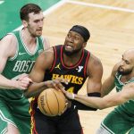 El guardia de los Boston Celtics, Derrick White (d), aleja el balón del delantero de los Atlanta Hawks, Bruno Fernando (c), mientras el centro de los Boston Celtics, Luke Kornet (i), defiende. EFE/EPA/CJ GUNTHER