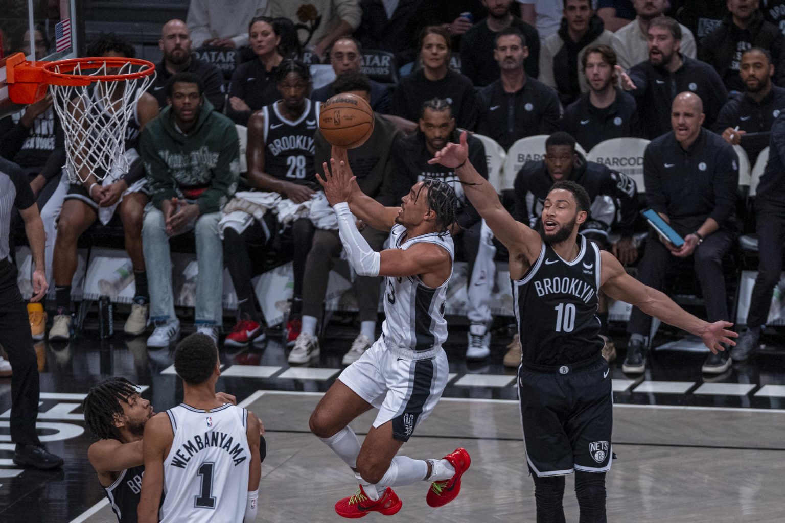 Tre Jones (c) de San Antonio Spurs salta a canasta sobre la marca de Ben Simmons (d) de Brooklyn Nets hoy, durante un partido de NBA disputado en el Barclays Center en Brooklyn, Nueva York (EE.UU.). EFE/ Ángel Colmenares