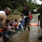 Migrantes bajan de canoas para ser trasladados a una estación de recepción migratoria en Lajas Blancas, Metetí, Darién (Panamá). Fotografía de archivo. EFE/ Bienvenido Velasco