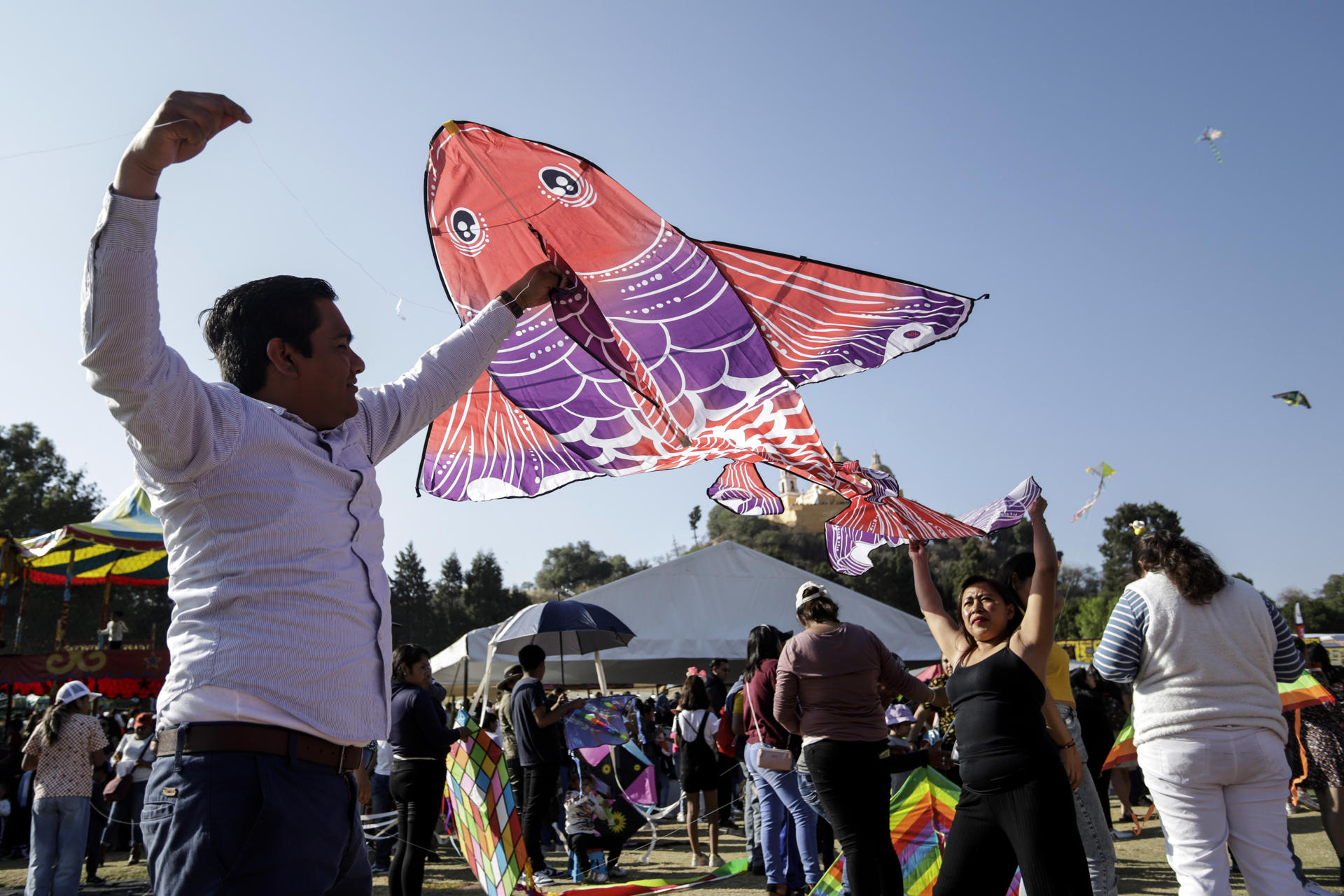 Personas participan en el segundo día de actividades del Festival Volarte de papalotes gigantes este domingo, en el Parque Intermunicipal en San Andrés Cholula, Puebla (México).  EFE/Hilda Ríos
