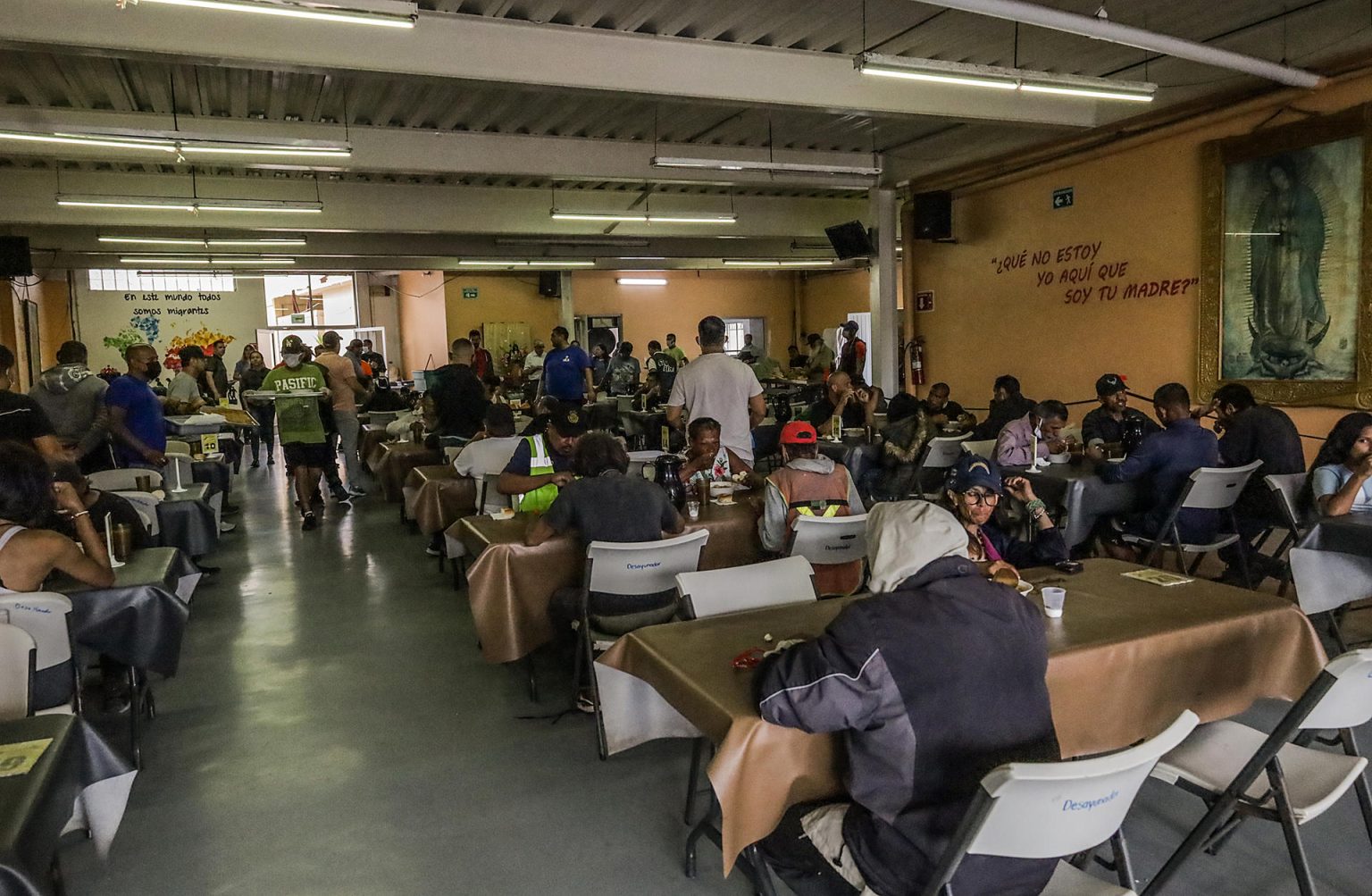 Fotografía de archivo de migrantes y personas en situación de calle acuden por alimentos a un centro migratorio en California. EFE/Joebeth Terríquez