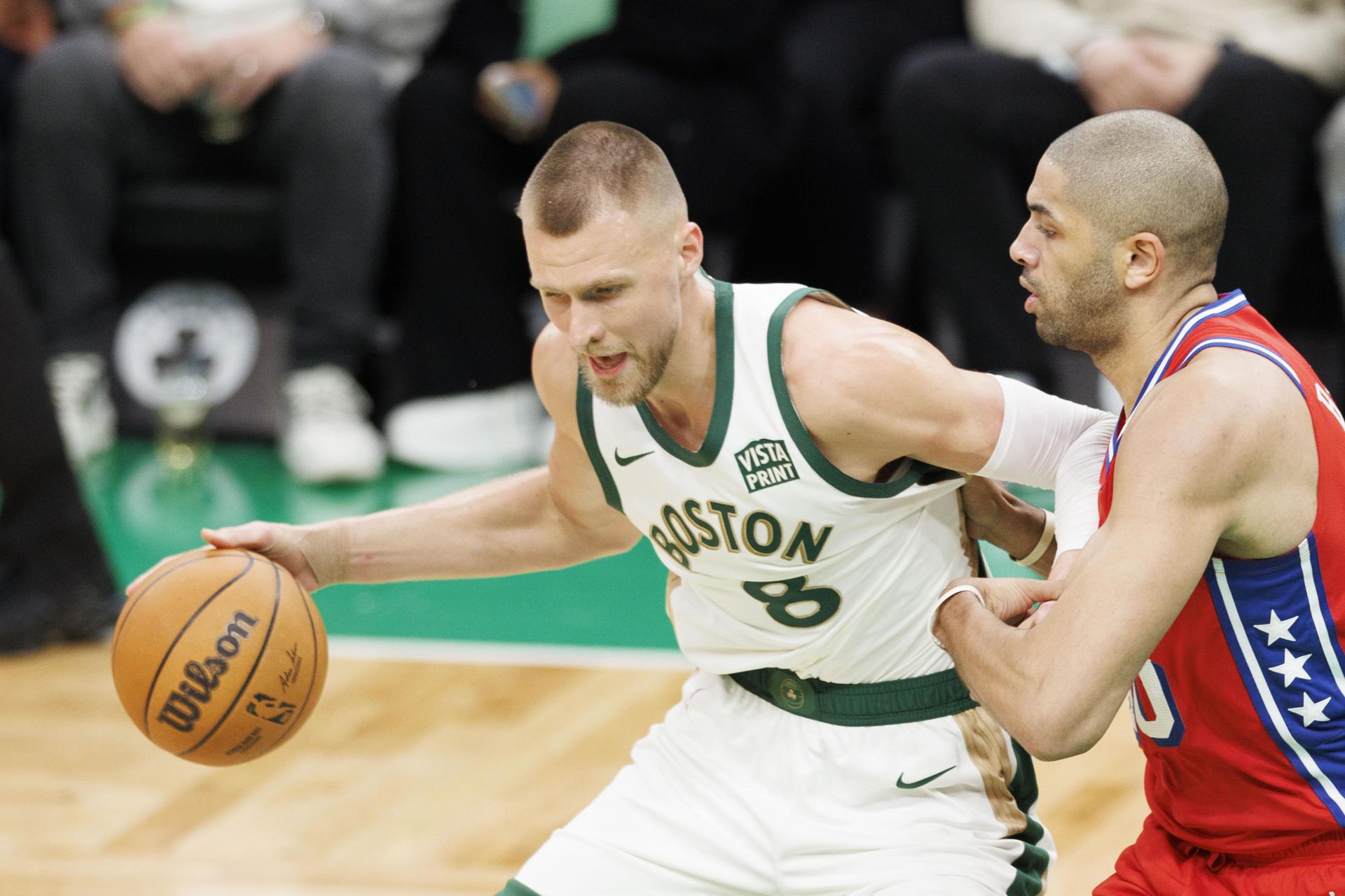 Kristaps Porzingis (i),ala pívot de los Celtics de Boston, fue registrado este martes, 27 de febrero, al intentar superar la marca de Nicolas Batum (d), de los 7ers de Filadelfia, duante un partido de la NBA, en Boston (Massachusetts, EE.UU.). EFE/CJ Gunther
