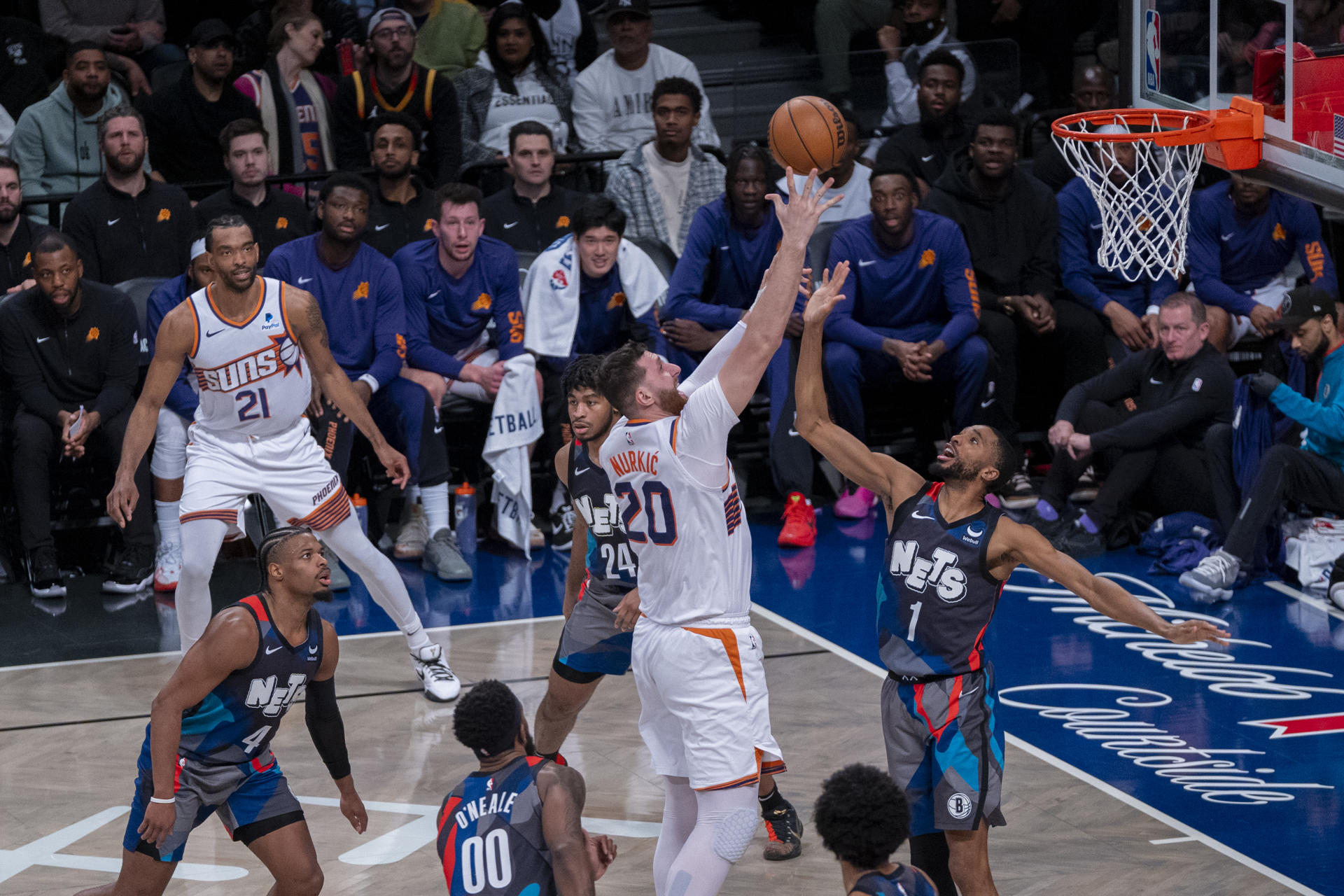 Jusuf Nurkić (c) de los Suns salta a la canasta bajo la marca de Mikal Bridges (d) de los Nets hoy, durante un partido de baloncesto de la NBA entre Brooklyn Nets y Phoenix Suns, disputado en el pabellón deportivo multiusos Barclays Center en el barrio de Prospect Heights, Brooklyn, Nueva York (EE.UU.). EFE/ Ángel Colmenares
