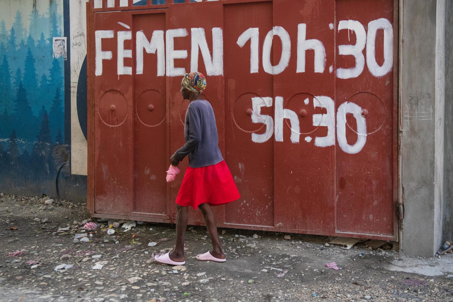 Una mujer cruza una barrera a la entrada de un barrio en Puerto Príncipe (Haití). EFE/ Johnson Sabin