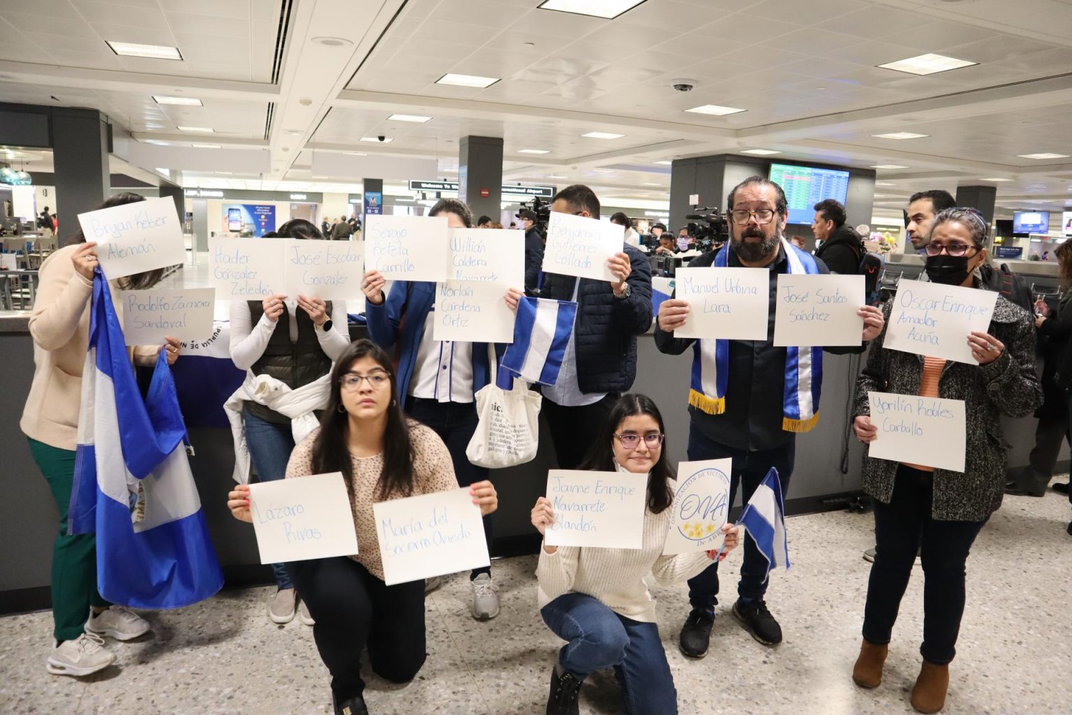 Fotografía de archivo del 3 de febrero de 2023 donde aparecen unas personas sosteniendo hojas con los nombres de los presos políticos nicaragüenses, expulsados de su país, mientras esperan su llegada en el aeropuerto de Dulles, Virginia (EE. UU). EFE/Octavio Guzmán