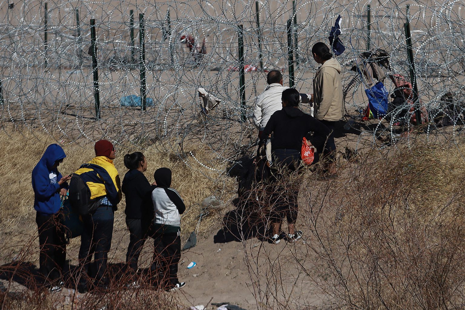 Migrantes se acercan a una concertina que divide a México de los Estados Unidos, este domingo en Ciudad Juárez, estado de Chihuahua (México). EFE/Luis Torres