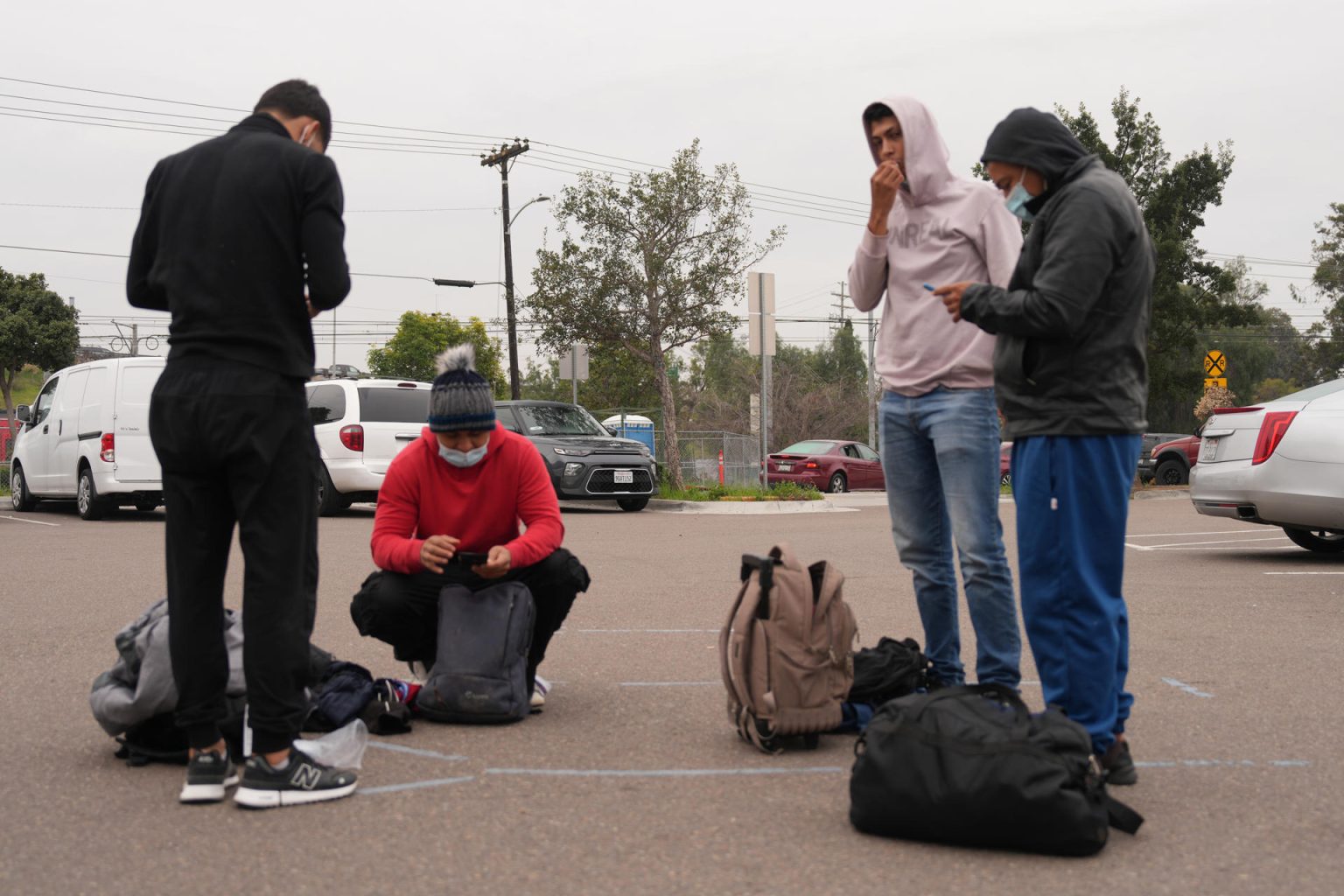 Un grupo de migrantes liberados por la Patrulla Fronteriza revisa sus maletas este lunes, en San Diego, California (EE.UU.). EFE/ Manuel Ocaño