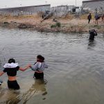 Migrantes se preparan para cruzar el Río Bravo, en la frontera que divide a México de los Estados Unidos, este jueves en Ciudad Juárez (México). EFE/Luis Torres