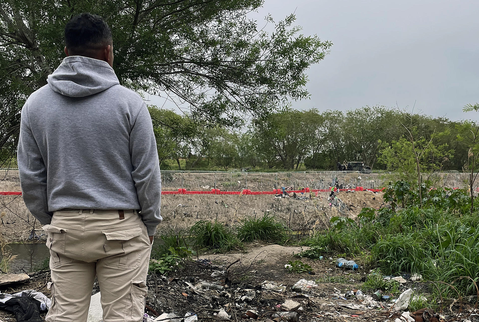 Un migrante observa la cerca junto al río Bravo en la frontera que divide a México de los Estados Unidos, este jueves en la ciudad de Matamoros, estado de Tamaulipas (México). EFE/Abraham Pineda Jácome
