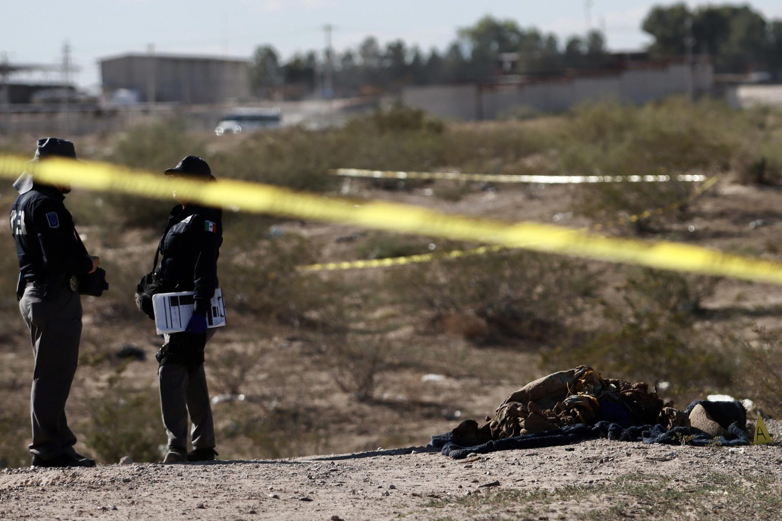 Personal de la policía municipal resguardan la zona donde se localizó una fosa clandestina con seis cuerpos, este jueves en Ciudad Juárez (México). EFE/Luis Torres