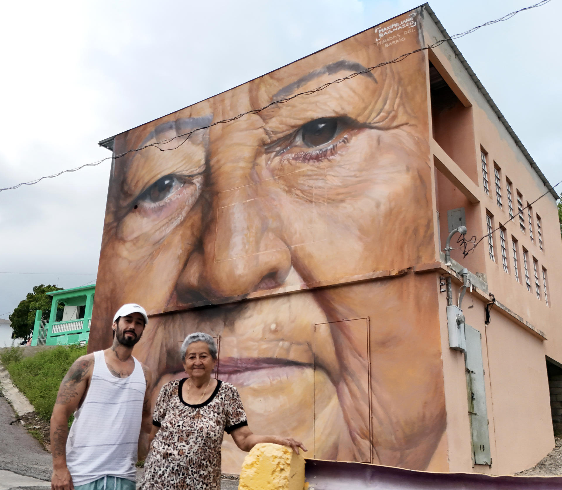 Fotografía cedida por la organización 'Arte para Unir' donde aparece el artista argentino Maximiliano Bagnasco mientras posa con doña Monserrate, una vecina del local, frente a su mural que forma parte del proyecto 'Miradas del barrio', realizado en el barrio de El Cerro, en Yauco (Puerto Rico). EFE/Arte para Unir /SOLO USO EDITORIAL/SOLO DISPONIBLE PARA ILUSTRAR LA NOTICIA QUE ACOMPAÑA (CRÉDITO OBLIGATORIO)
