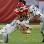 Fotografía de archivo en donde se observa a Travis Kelce (c) de los Kansas City Chiefs siendo abordado por el linebacker de los Miami Dolphins Andrew Van Ginkel (i) y el tackle defensivo de los Miami Dolphins Christian Wilkins (d) durante un juego de la NFL. EFE/EPA/RONALD WITTEK