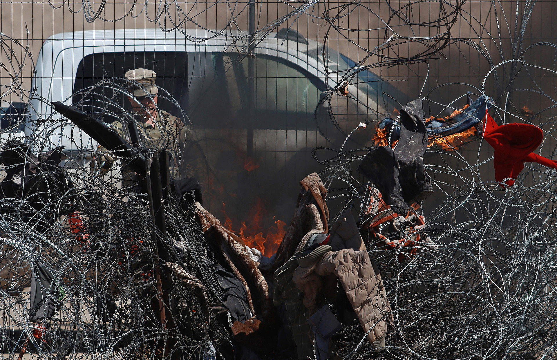 Personal de la Guardia Nacional de Texas, prende fuego a ropa en una cerca de alambres en la frontera que divide a México de los Estados Unidos, este jueves en Ciudad Juárez (México). EFE/Luis Torres
