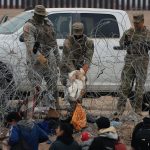 Fotografía de archivo de soldados estadounidenses que esperan tras una alambrada de navajas y púas mientras migrantes intentan pasar. EFE/ Luis Torres