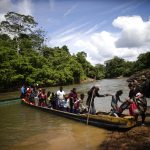 Migrantes descienden de una canoa antes de llegar a la Estación de Recepción Migratoria (ERM) de Lajas Blancas luego de atravesar la selva del Darién (Panamá). EFE/ Bienvenido Velasco