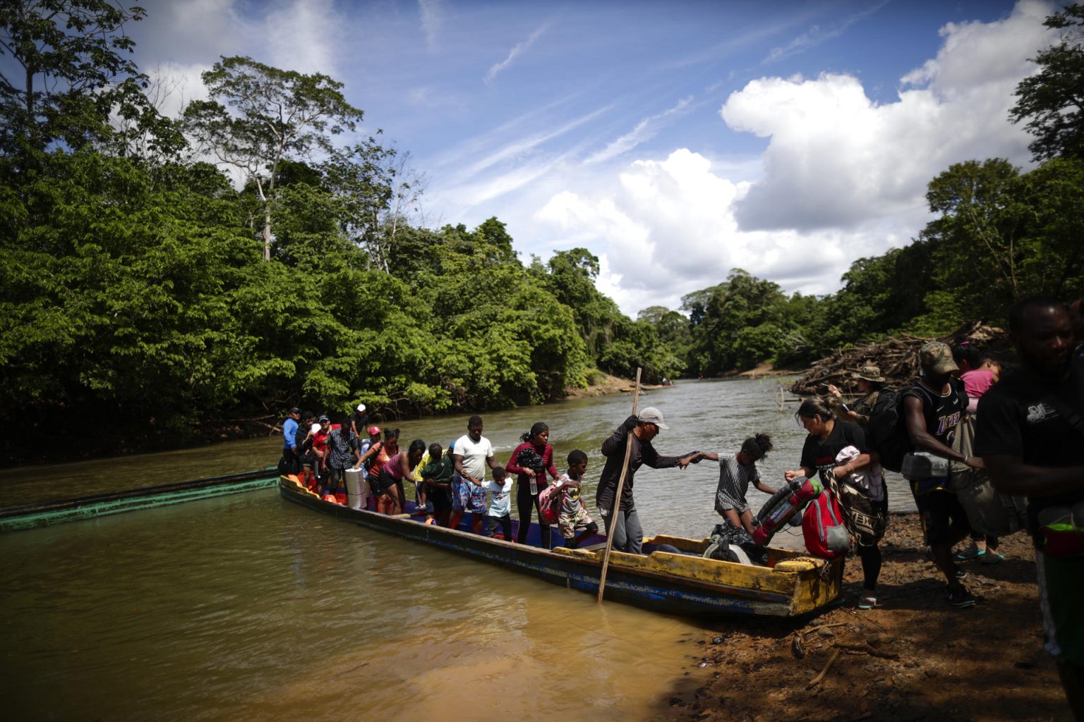 Migrantes descienden de una canoa antes de llegar a la Estación de Recepción Migratoria (ERM) de Lajas Blancas luego de atravesar la selva del Darién (Panamá). EFE/ Bienvenido Velasco