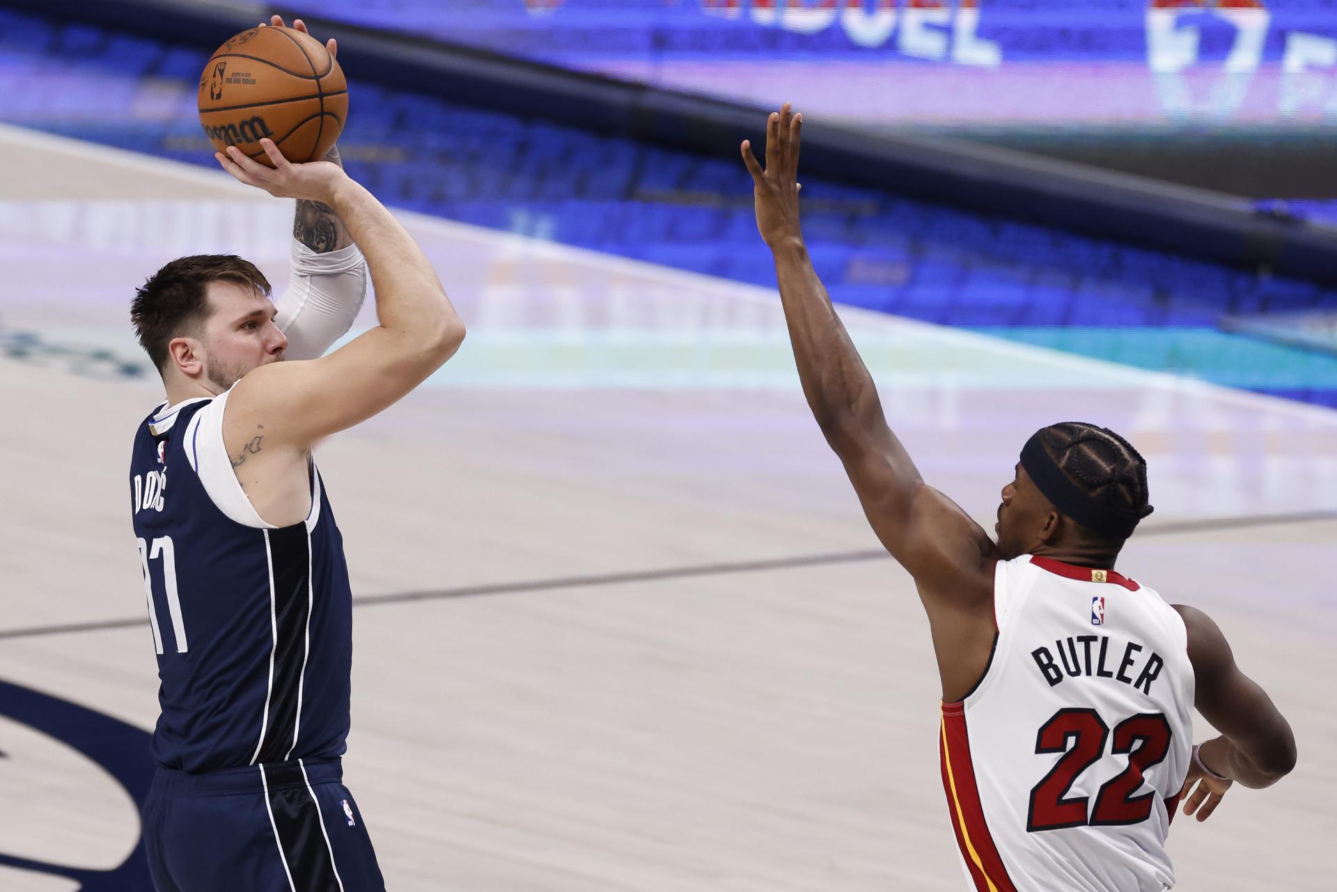 El guardia de los Dallas Mavericks, Luka Doncic, de Eslovenia (i), toma un tiro sobre el delantero del Miami Heat, Jimmy Butler (d), durante la segunda mitad de un partido de la NBA entre los Dallas Mavericks y los Miami. Calor en Dallas, Texas, EE.UU. EFE/EPA/ADAM DAVIS
