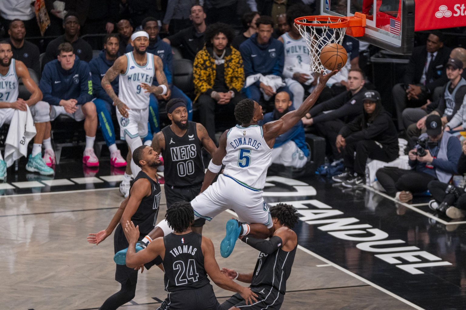 Fotografía de archivo en la que se registró a Anthony Edwards (c), escolta de los Timberwolves de Minnesota, al saltar y atacar el aro que defendían los Nets de Brooklyn, durante un partido de la NBA, en Nueva York (NY, EE.UU.). Edwards se inventó este lunes, 18 de marzo, un mate extraordinario que enloqueció a las redes sociales y que dará la vuelta al mundo en la victoria a domicilio de su equipo 104-114 sobre los Jazz de Utah. EFE/Ángel Colmenares