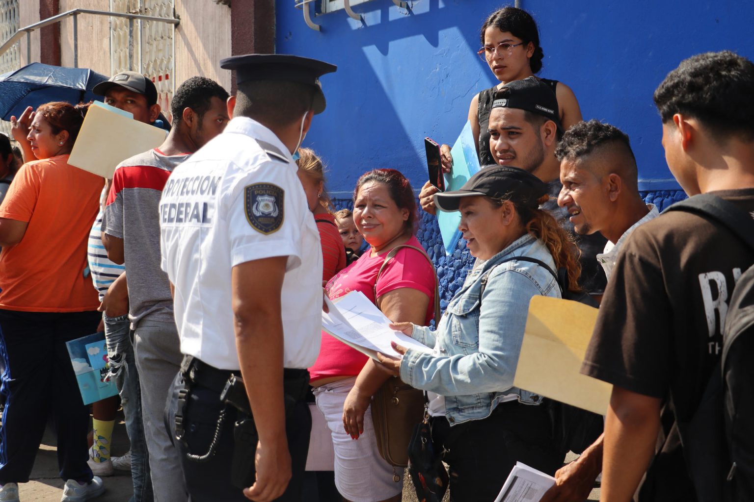 Autoridades hablan con migrantes que hacen fila en espera de resolver su situación migratoria en las instalaciones de la Comisión Nacional de Ayuda a Refugiados (Comar) este miércoles, en la ciudad de Tapachula en el estado de Chiapas (México). EFE/Juan Manuel Blanco