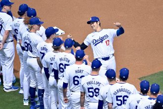 El lanzador estrella de Los Dodgers de Los Ángeles, el japonés Shohei Ohtani (d), fue registrado este jueves, 28 de marzo, al saludar a sus compañeros en su debut con el equipo californiano y antes del inicio de un partido de la MLB contra los Cardenales de San Luis, en el Dodger Stadium, en Los Ángeles (California, EE.UU.). EFE/Arrmando Arorizo