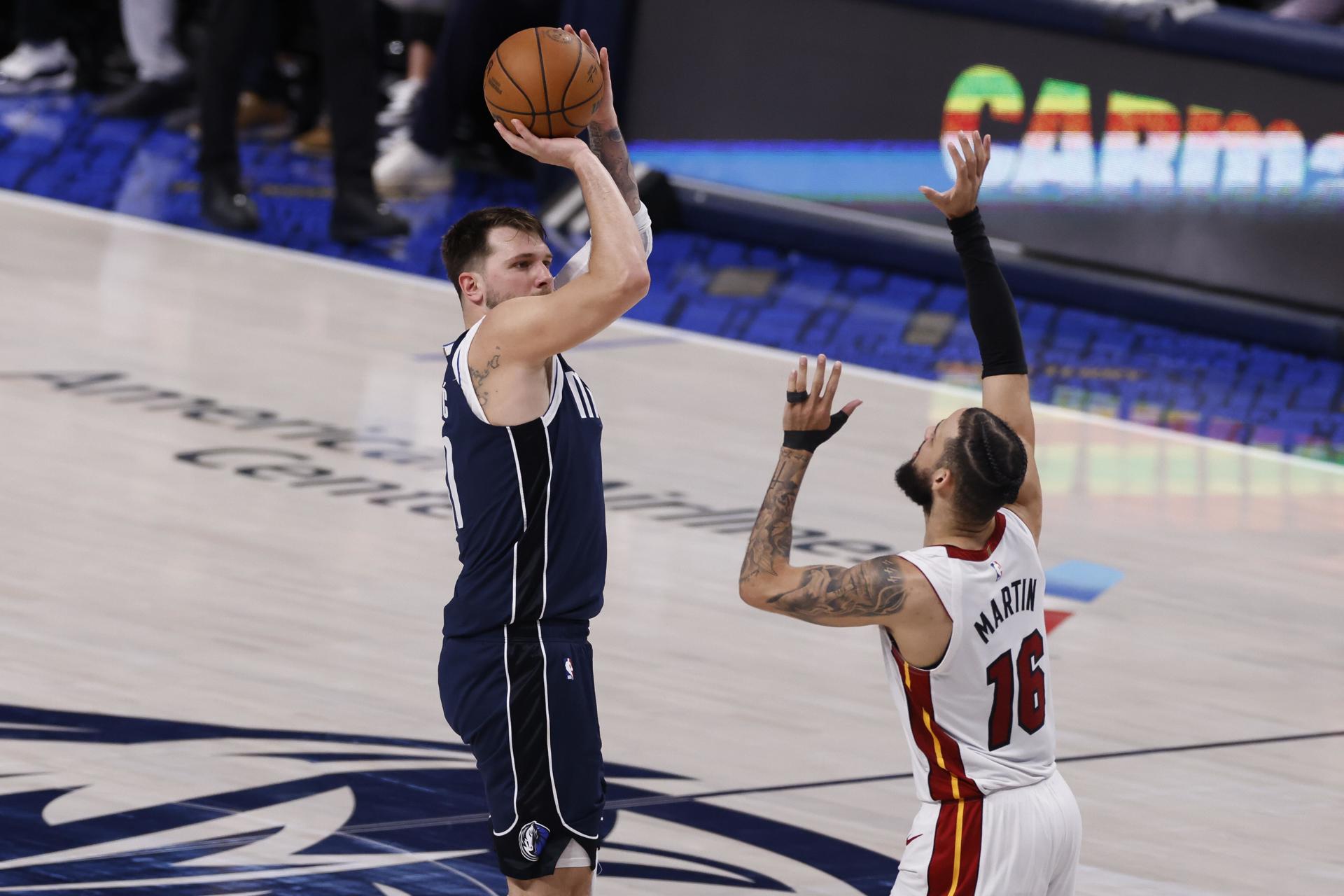 El guardia de los Dallas Mavericks, Luka Doncic, de Eslovenia (I), toma un tiro sobre el delantero del Miami Heat, Caleb Martin (d), durante la segunda mitad de un partido de la NBA entre los Dallas Mavericks y los Miami. Calor en Dallas, Texas, EE.UU. EFE/EPA/ADAM DAVIS
