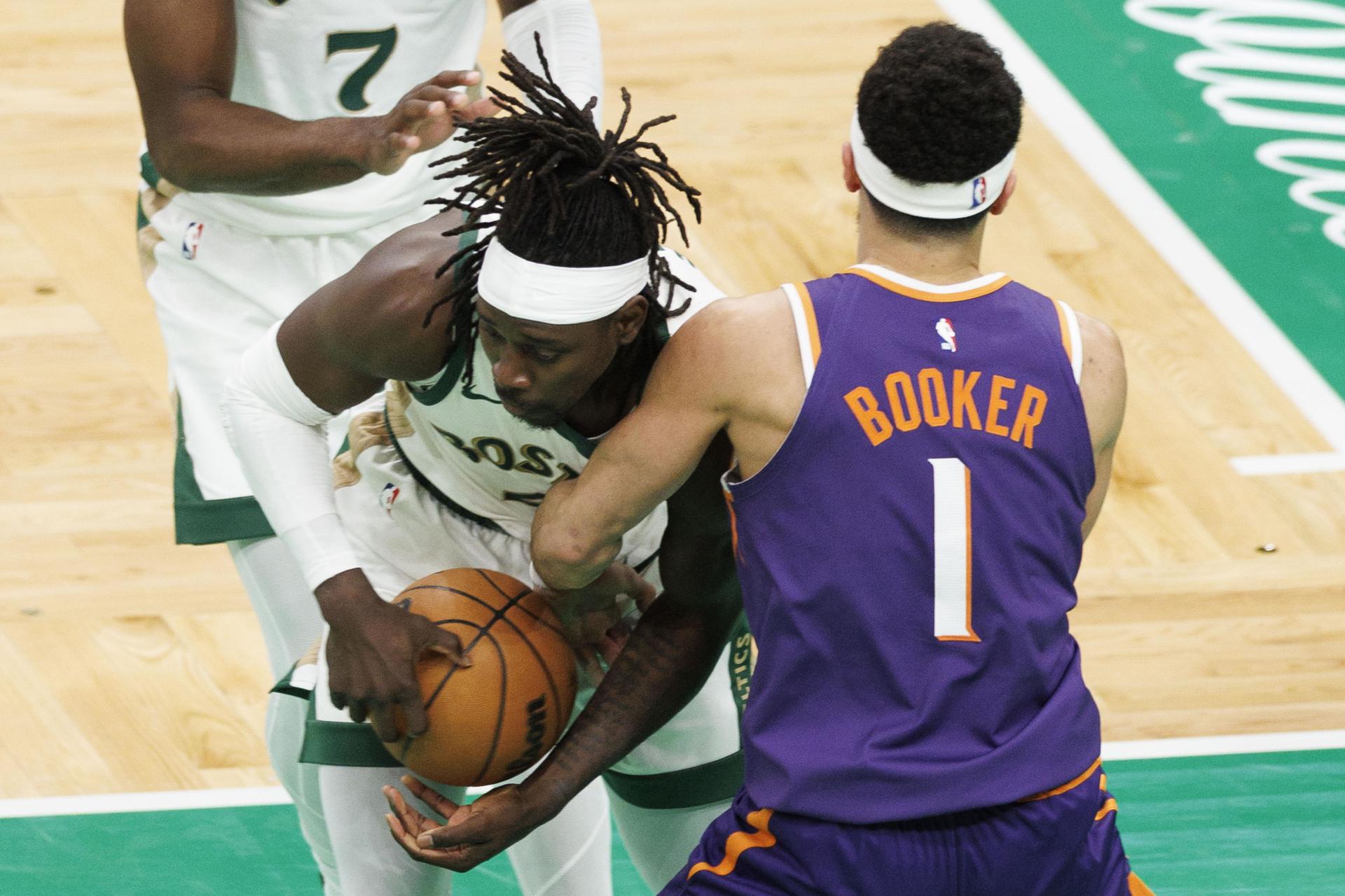 Jrue Holiday (c), escolta de los Celtics de Boston, fue registrado este jueves, 14 de marzo, al intentar superar la marca de Devin Booker (d), guardia de los Suns de Phoenix, durante un partido de la NBA, en el coliseo TD Garden, en Boston (Massachusetts, EE.UU.). EFE/CJ Gunther
