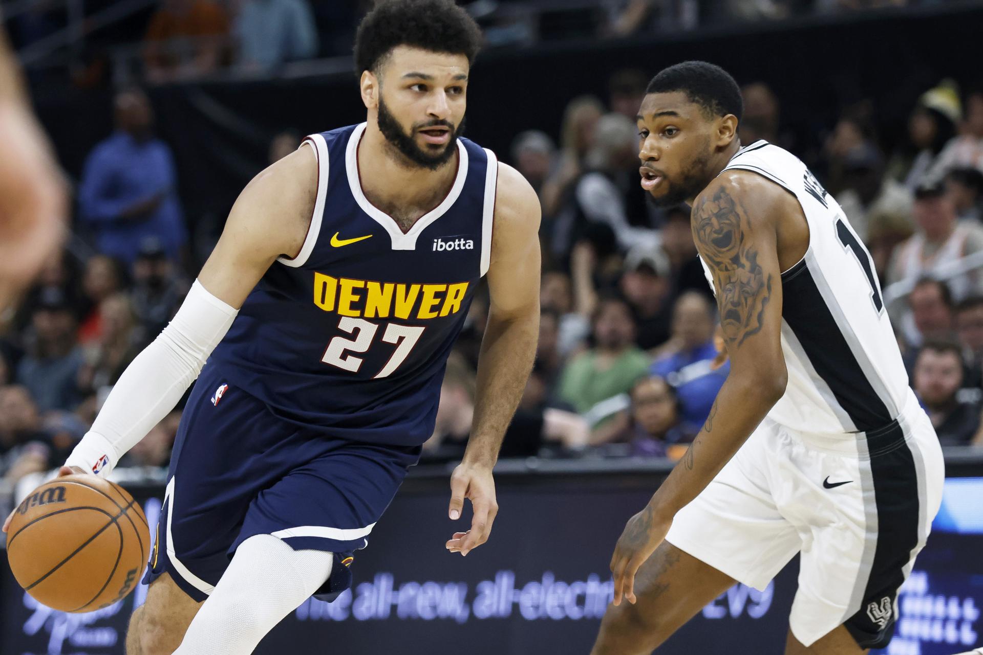 El canadiense Jamal Murray (i), base de los Nuggets de Denver, fue registrado este viernes, 15 de marzo, al intentar superar la marca de Blake Wesley, guardia de los Spurs de San Antonio, durante un partido de la NBA, en Austin (Texas, EE.UU.). EFE/Adam Davis
