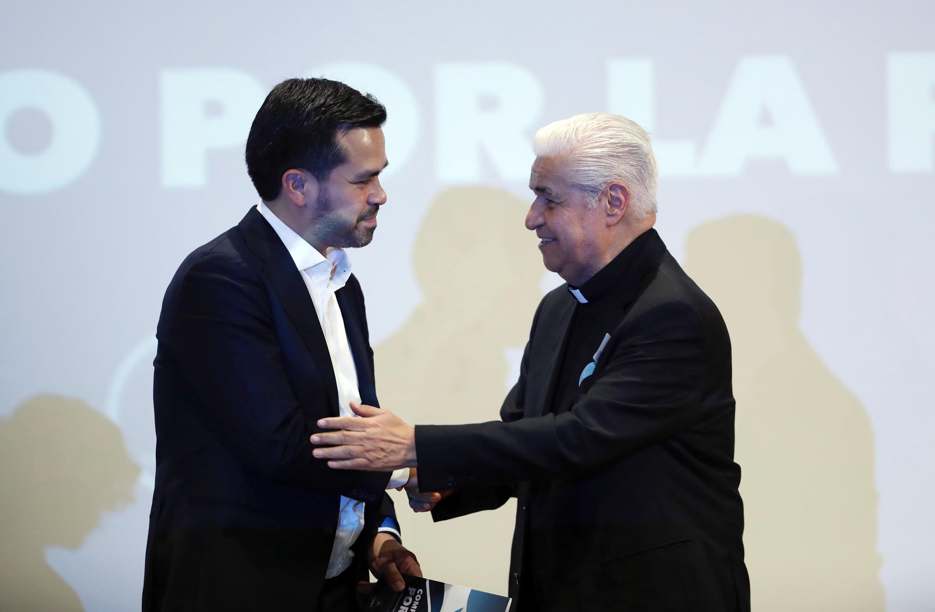 El candidato a la presidencia de México por el Movimiento Ciudadano (MC), Jorge Álvarez Máynez (i), y el presidente del Episcopado Mexicano, Rogelio Cabrera (d), se dan la mano tras firmar el compromiso por la paz este lunes, en la Ciudad de México (México).EFE/ Sáshenka Gutiérrez
